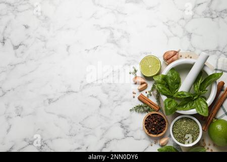 Différentes épices naturelles et herbes sur table en marbre blanc, plat. Espace pour le texte Banque D'Images