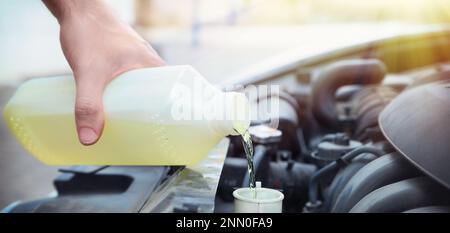 Homme remplissant le radiateur de voiture avec de l'antigel à l'extérieur, gros plan Banque D'Images