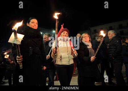 Les personnes aux drapeaux de la paix , les signes de protestation et les torches participent à un rassemblement et à une marche pour exiger la fin de la guerre en Ukraine. Banque D'Images