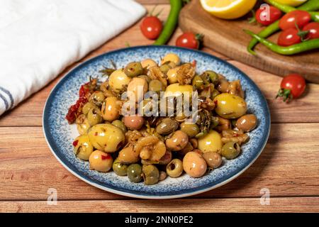 Olives vertes mélangées. Salade d'olives vertes sur fond de bois. Saveurs méditerranéennes Banque D'Images