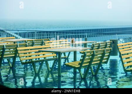 Le café est vide sur la terrasse du ferry en raison de la pluie. Tables et bancs sur une plate-forme de ferry par temps pluvieux Banque D'Images