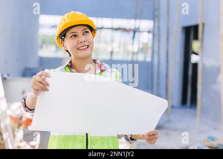 Femme asiatique travailleuse d'ingénieur dans le chantier de construction. Architecte intelligent femme travaillant dans une suite de sécurité. Banque D'Images