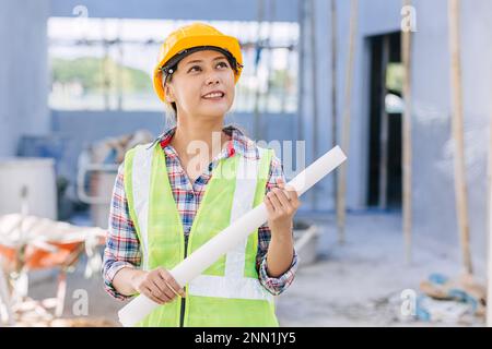 Ingénieur architecte constructeur asiatique intelligent femme travailleur fierté de travailler sur le chantier de construction heureux sourire. Banque D'Images