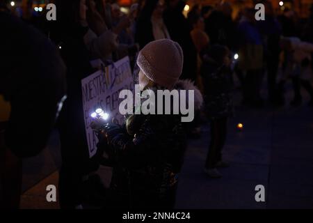 Pampelune, Espagne. 24th févr. 2023. Une fille joue avec une lampe de poche pendant le rallye. La population ukrainienne s'est réunie sur la place du château de Pampelune à l'occasion du premier anniversaire de l'invasion à grande échelle de l'Ukraine par la Russie. Crédit : SOPA Images Limited/Alamy Live News Banque D'Images