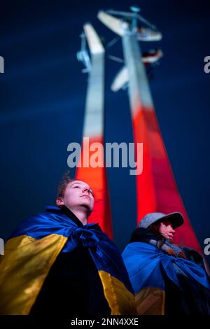 Gdansk, Pologne. 24th févr. 2023. Les femmes s'enveloppent de drapeaux ukrainiens sur la place de solidarité lors d'un rassemblement à l'occasion de l'anniversaire de l'invasion russe en Ukraine. Les gens se sont rassemblés sur la place de solidarité pour participer à un rassemblement "européen" en faveur de l'Ukraine et pour exprimer l'espoir de paix et de fin de la guerre. Crédit : SOPA Images Limited/Alamy Live News Banque D'Images