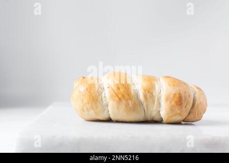 Un rouleau de saucisse sur un plateau en marbre, un rouleau de saucisse torsadé sur un plateau en marbre, de grands cochons dans une couverture en-cas Banque D'Images