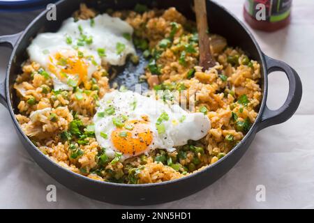 Riz frit Kimchi aux pois, œuf frit et sauce sriracha Banque D'Images