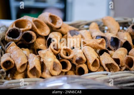 Cannoli frits et sautés dans un panier sur le comptoir du marché alimentaire Banque D'Images