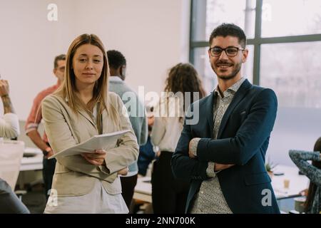 Une photo de face de collègues masculins et féminins posant Banque D'Images