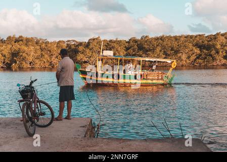 Valentica, Bahia, Brésil - 09 septembre 2022 : bateau naviguant sur la rivière una en fin d'après-midi tout en pêchant à la maison sur la rive. Ville de Valenca, Banque D'Images