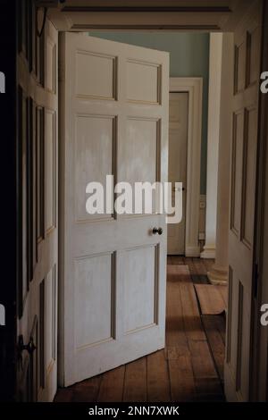 Intérieur d'une maison de ville géorgienne à Londres, Angleterre. Une porte mène dans un couloir d'une maison élégante avec une belle lumière tombant sur le travail de panneau. Banque D'Images