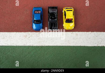 Une photo de 3 voitures jouets placées au bord de la ligne de cour, après montage. Concept pour prêt à la course. Banque D'Images