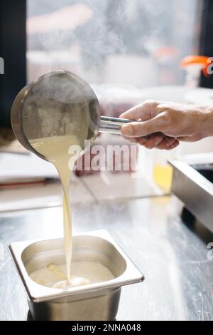 Le processus de fabrication de ganache, une garniture pour un croissant de pistache. La crème affecte le chocolat blanc. Banque D'Images