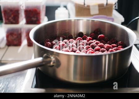 Gros plan. Processus dans la cuisine, caramélisation des cerises. Banque D'Images