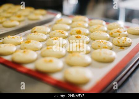 Macarons fraîchement cuits sur une plaque de cuisson. Banque D'Images