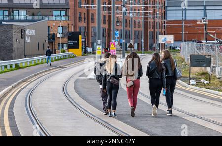 Groupe d'adolescentes marchant le long des lignes de tramway sur Ocean Drive, Leith, Édimbourg, Écosse, Royaume-Uni Banque D'Images