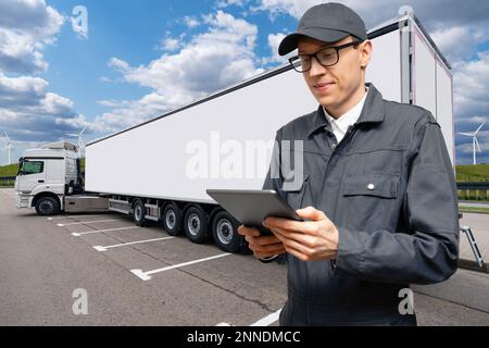 Manager avec une tablette numérique à côté des camions. Gestion de parc Banque D'Images