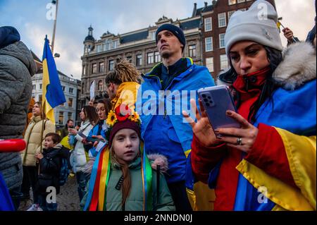Une famille ukrainienne est vue à l'écoute des discours tout en portant des drapeaux ukrainiens pendant la manifestation. À Amsterdam, Des milliers de personnes et de partisans ukrainiens ont marché du Museumplein à la place du Dam pour rappeler à la société hollandaise que la guerre se poursuit et que des Ukrainiens courageux défendent leur pays et que l'Ukraine a besoin d'un soutien pour cela.parce que le vendredi 24th février marque un an depuis que la Russie a commencé son Guerre contre l'Ukraine, plusieurs manifestations ont été prévues aux pays-Bas. Plus de huit millions de personnes ont été contraintes de quitter l'Ukraine, et cinq millions d'autres Banque D'Images