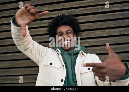 Un bon gars afro-américain riait en prenant le selfie sur fond de bois. Portrait Banque D'Images