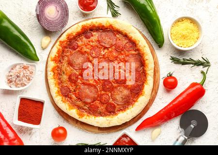Composition avec une délicieuse pizza au pepperoni et des ingrédients sur fond de grunge blanc Banque D'Images
