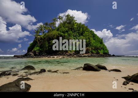 Les eaux claires le long de la côte d'Amanave sur l'île de Tutuila, Samoa américaines, avec sa plage de sable blanc et son feuillage luxuriant Banque D'Images