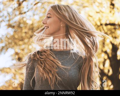 Adolescente blonde secouant ou en effleurant ses cheveux - joie de vivre concept Banque D'Images