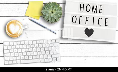 Text HOME OFFICE sur la visionneuse sur table en bois avec clavier d'ordinateur, notes adhésives et tasse de café, travaillant de la maison pendant la pandémie de coronavirus Banque D'Images
