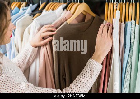 Femme choisissant la robe lors du shopping vêtements habillement Banque D'Images