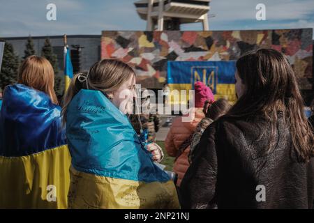 Seattle, États-Unis. 25th févr. 2023. Des manifestants enveloppés de drapeaux ukrainiens participent à la manifestation. Des manifestants pour la démocratie se sont rassemblés au Seattle Center pour marquer le premier anniversaire de l'invasion de l'Ukraine par la Russie. L'événement, organisé par des groupes locaux ukrainiens-américains, a attiré des participants de toute la région qui se sont réunis pour exiger la fin de l'agression russe et le retour à un régime démocratique en Ukraine. Crédit : SOPA Images Limited/Alamy Live News Banque D'Images