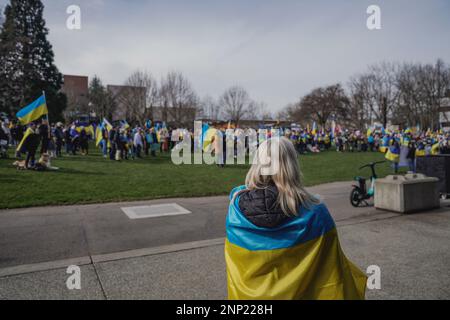 Seattle, États-Unis. 25th févr. 2023. Un manifestant s'est enveloppé dans un drapeau ukrainien et a marché à travers le Seattle Center pendant la manifestation. Des manifestants pour la démocratie se sont rassemblés au Seattle Center pour marquer le premier anniversaire de l'invasion de l'Ukraine par la Russie. L'événement, organisé par des groupes locaux ukrainiens-américains, a attiré des participants de toute la région qui se sont réunis pour exiger la fin de l'agression russe et le retour à un régime démocratique en Ukraine. Crédit : SOPA Images Limited/Alamy Live News Banque D'Images