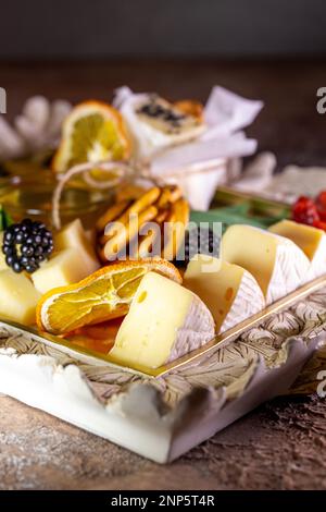 Assortiment de fromages sur un plateau avec noix et miel. Banque D'Images