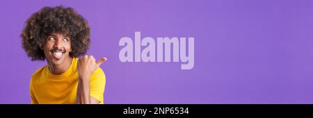 Un homme africain heureux qui pointe vers le côté Banque D'Images