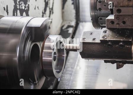 Une fraise dans une machine CNC coupe une pièce de métal qui tourne à grande vitesse Banque D'Images