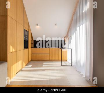 Cuisine moderne et lumineuse dans une nouvelle maison de luxe, planchers de bois franc, armoires en bois sombre. Banque D'Images