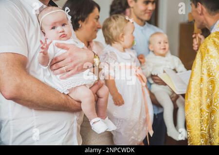 Le prêtre conduit le rite du baptême des enfants dans l'Église danoise Banque D'Images