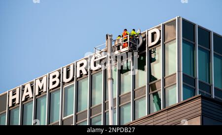 Hambourg, Allemagne. 26th févr. 2023. Le lettrage « Hamburg Süd » est retiré de l'ancien siège de la compagnie maritime du même nom à l'aide d'un élévateur télescopique. Après environ 60 ans, le lettrage est retiré du bâtiment et partiellement remplacé par le nouveau nom du bâtiment. Credit: Daniel Bockwoldt/dpa/Daniel Bockwoldt/dpa/Alay Live News Banque D'Images
