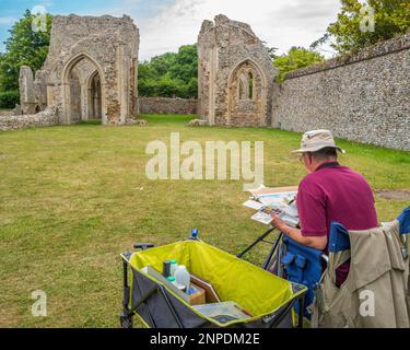 Un artiste peint les ruines de l'abbaye de Creake. Banque D'Images