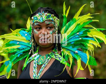 Un membre du Carnaval indien de Leeds West fait une pause en se présentant au Carnaval de Harrogate en portant un costume et des plumes traditionnels. Banque D'Images