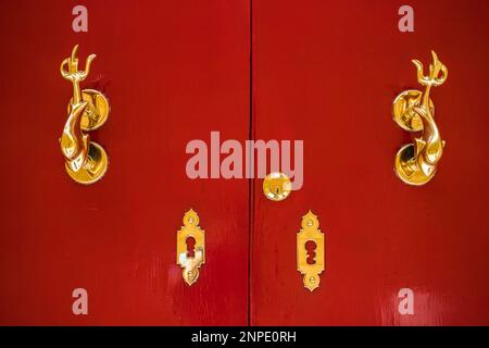 Golden porte knockers vu sur une porte rouge vif à Mdina à Malte. Banque D'Images