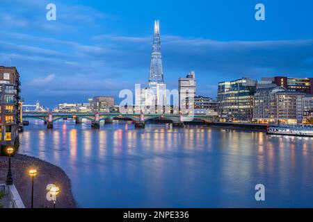 Le pont Southwark et le Shard vus de la rive de la Tamise au crépuscule. Banque D'Images