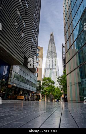 Vue sur le Shard qui domine la ligne d'horizon de Londres vue depuis le sol à More London Riverside. Banque D'Images