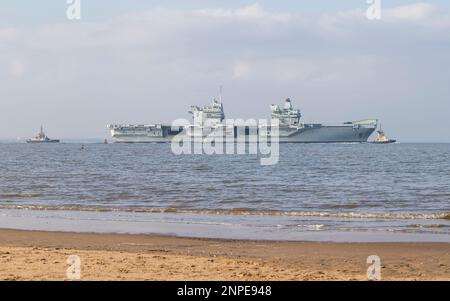 Des remorqueurs et des bateaux de police soutiennent le porte-avions HMS Queen Elizabeth lorsqu'elle quitte Liverpool. Banque D'Images