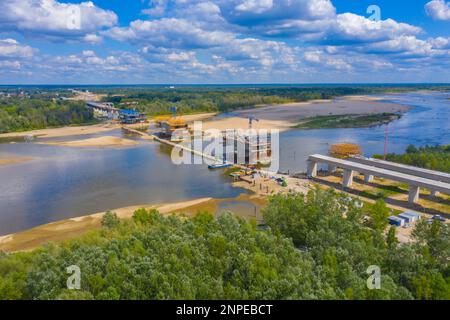 Prise de vue aérienne passant au-dessus d'un projet de construction de pont au coucher du soleil à Vistule près de Varsovie. Construction du pont MOST Polnocny. Pologne Banque D'Images