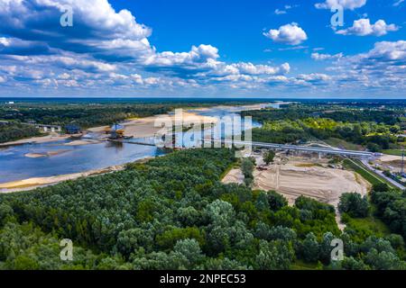 Prise de vue aérienne passant au-dessus d'un projet de construction de pont au coucher du soleil à Vistule près de Varsovie. Construction du pont MOST Polnocny. Pologne Banque D'Images