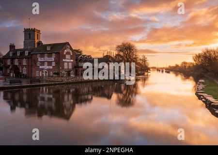 Les bâtiments de Wareham Quay se reflètent dans la rivière Frome au lever du soleil. Banque D'Images