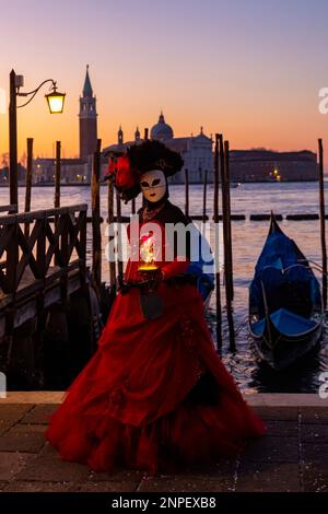 Carnival gardien vêtu d'un magnifique costume et masque pendant le Carnival de Venise 2023 tôt le matin à la place St Marks, Venise, Italie en février Banque D'Images