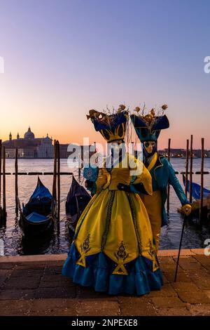 Carnaval des goers vêtus de magnifiques costumes et masques pendant le carnaval de Venise 2023 tôt le matin à la place St Marks, Venise, Italie en février Banque D'Images