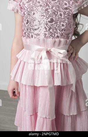 détails d'une robe rose brodée avec sequins et zone de ceinture plissée. Girgl portant une robe de fête de shyny. personne méconnaissable Banque D'Images