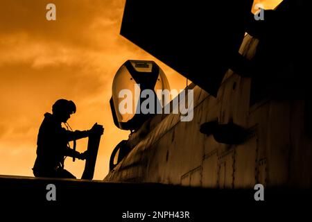 Le pilote de chasse monte à bord de son intercepteur de chasseur à réaction pour une mission d'entraînement au combat au coucher du soleil. Silhouette dramatique de pilote de héros se préparant à la guerre Banque D'Images