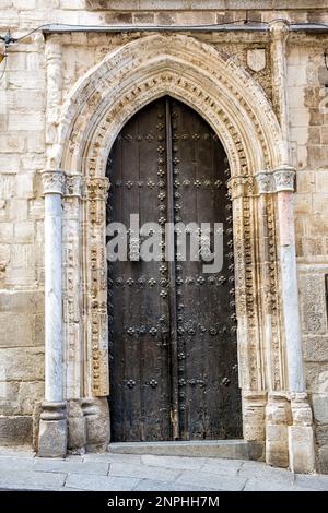 Ancienne porte en bois de la cathédrale de Tolède (cathédrale primate de Sainte Marie) avec cadre en pierre sculpté. Banque D'Images